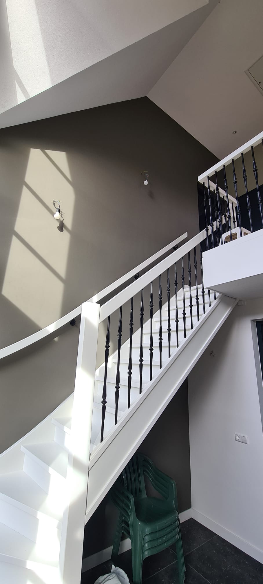 modern white staircase with black balusters and natural light shadows